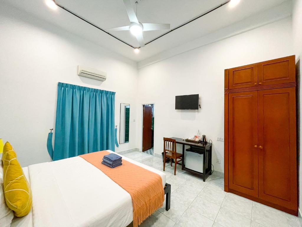a bedroom with a bed and a desk in it at Birdcage Boutique in Phnom Penh