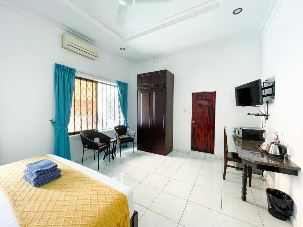 a bedroom with a bed and a desk and a table at Birdcage Boutique in Phnom Penh