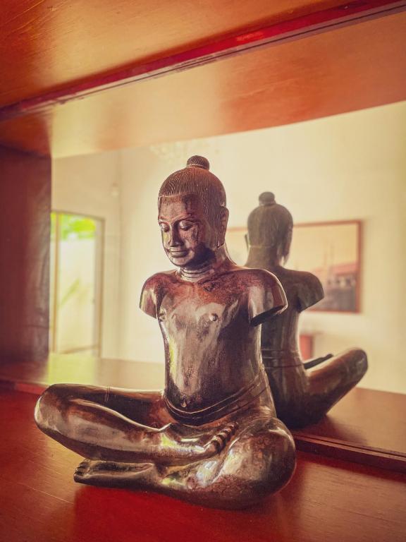 a statue sitting on a table in front of a mirror at Birdcage Boutique in Phnom Penh