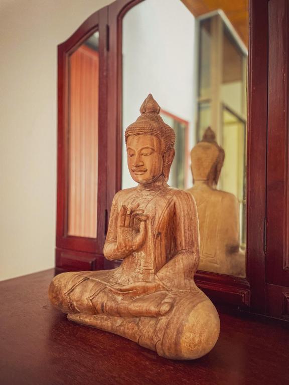 a wooden statue sitting on a table next to a mirror at Birdcage Boutique in Phnom Penh
