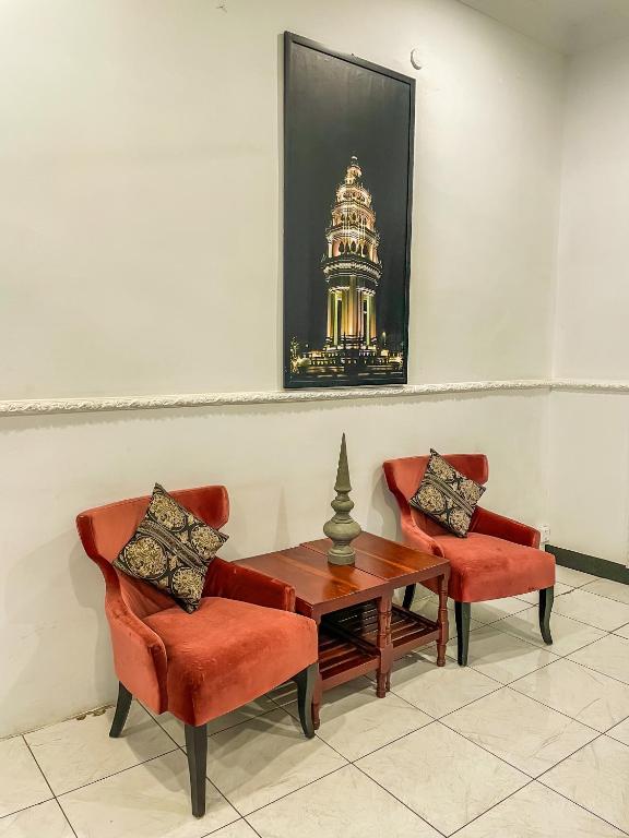 a room with two chairs and a table and a picture at Birdcage Boutique in Phnom Penh