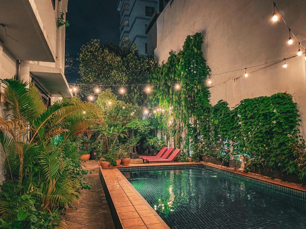 a swimming pool in a garden with lights and plants at Birdcage Boutique in Phnom Penh