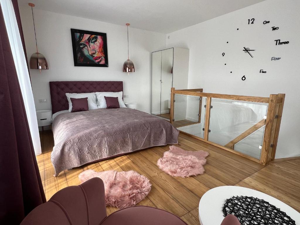 a bedroom with a bed and a clock on the wall at Bałtyckie Sarbinowo 13 in Sarbinowo