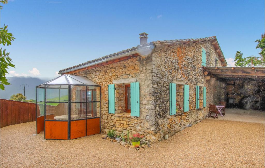 a small stone house with green shuttered windows at Gorgeous Home In Plan De Baix in Plan-de-Baix