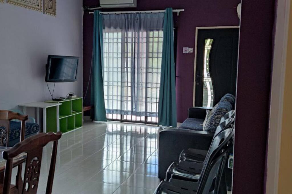 a living room with a couch and a television at As-Salam Homestay in Sungai Petani