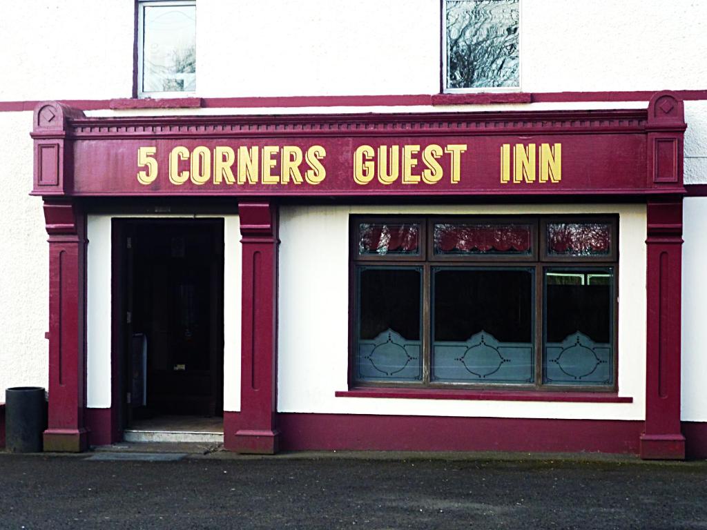 un edificio rojo y blanco con una posada en las esquinas en 5 Corners Guest Inn, en Ballyclare
