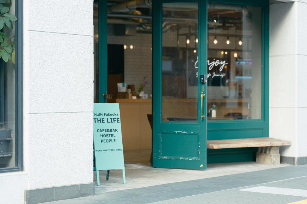 a sign in front of a store with a bench in front at HafH Fukuoka THE LIFE in Fukuoka