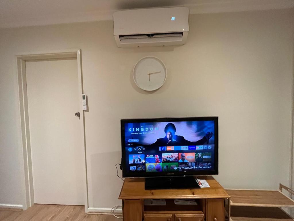 a flat screen tv sitting on a table in a room at Cosy 3 bedroom family home near beach and shops in Frankston