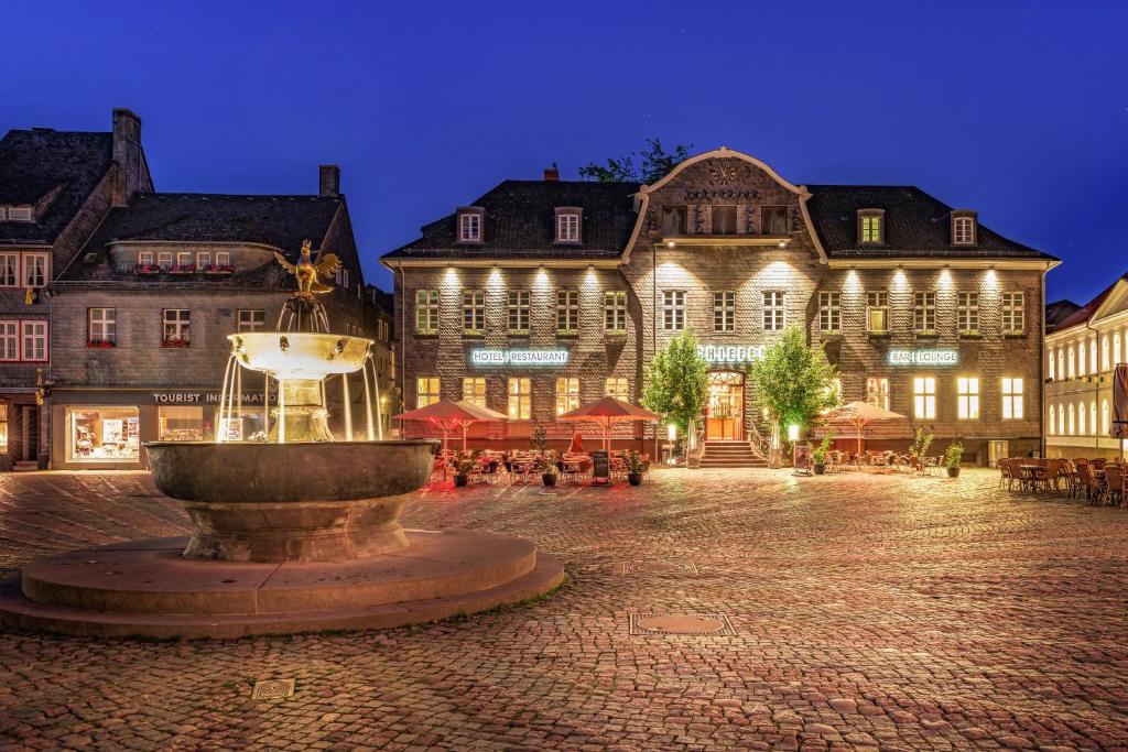 a fountain in a square in front of a building at Schiefer Suite Hotel & Apartments in Goslar