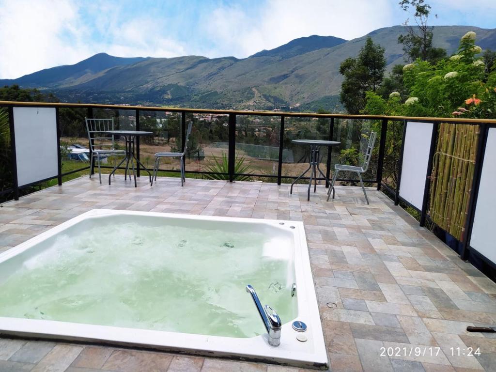 una bañera de hidromasaje en un patio con montañas al fondo en Casa chalet Campestre 2km, en Villa de Leyva