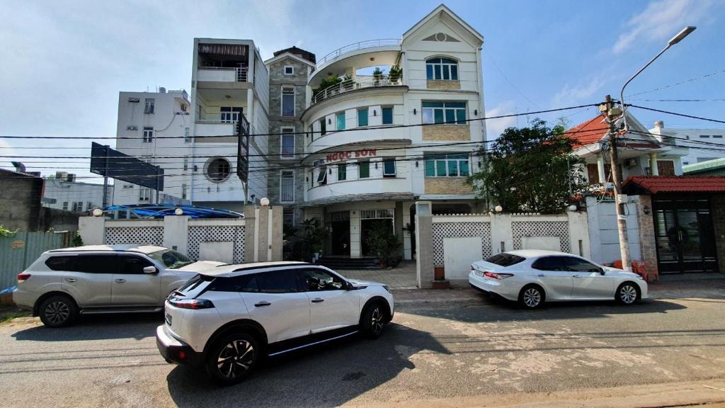 trzy samochody zaparkowane na parkingu przed budynkiem w obiekcie Ngoc Son Hotel w mieście Bien Hoa