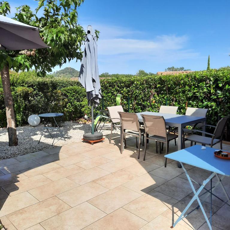 un patio avec une table, des chaises et un parasol dans l'établissement Ambiance-Provence, à Vidauban
