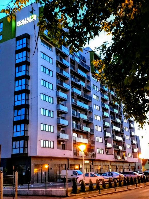 a large building with cars parked in front of it at Highsky Oradea Apartments in Oradea