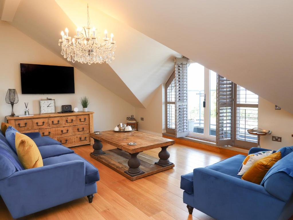 a living room with two blue couches and a table at 7 Four Seasons in St Ives