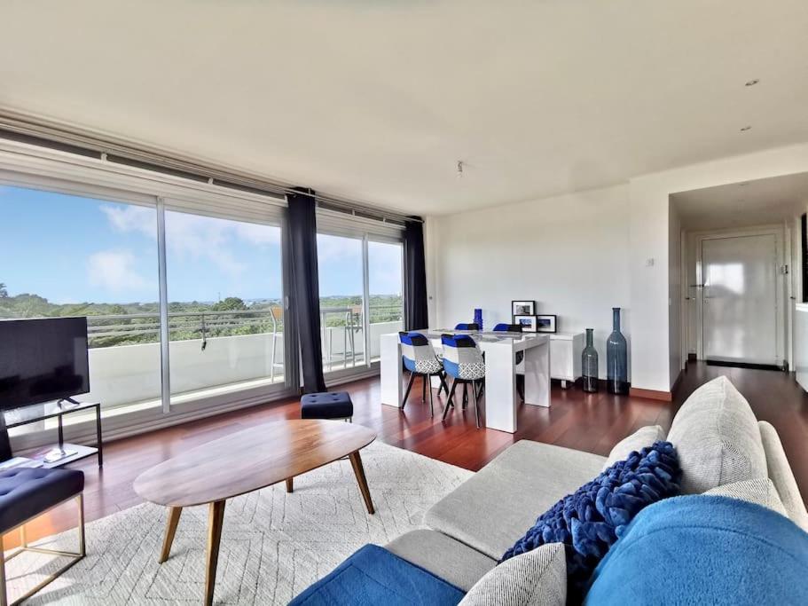 un salon avec un canapé bleu et une table dans l'établissement « La Canopée » / La Baule view, à La Baule