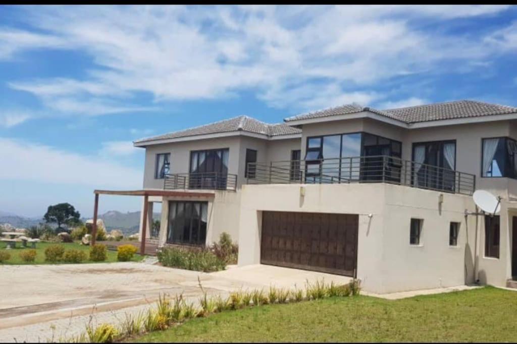 a large white house with a garage at Sermj Abode Nkoyoyo in Mbabane