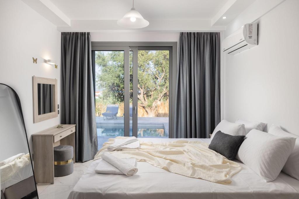 una camera da letto con un letto e una grande finestra di Villa Phoenix a Laganas