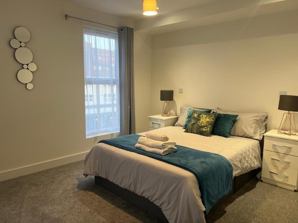 ein Schlafzimmer mit einem Bett mit Handtüchern darauf in der Unterkunft New modern 1 bedroom duplex apartment Hemel Hempstead High Street in Hemel Hempstead