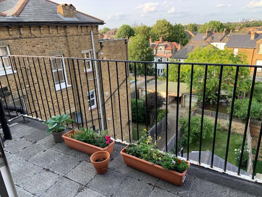 a balcony with pots of plants and a fence at London SW Home in London