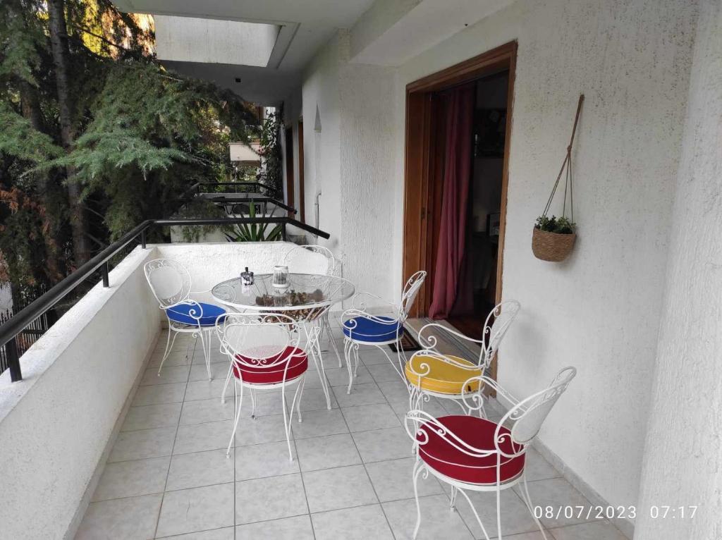 un patio con sedie e un tavolo sul balcone. di Lucy's apartment ad Atene