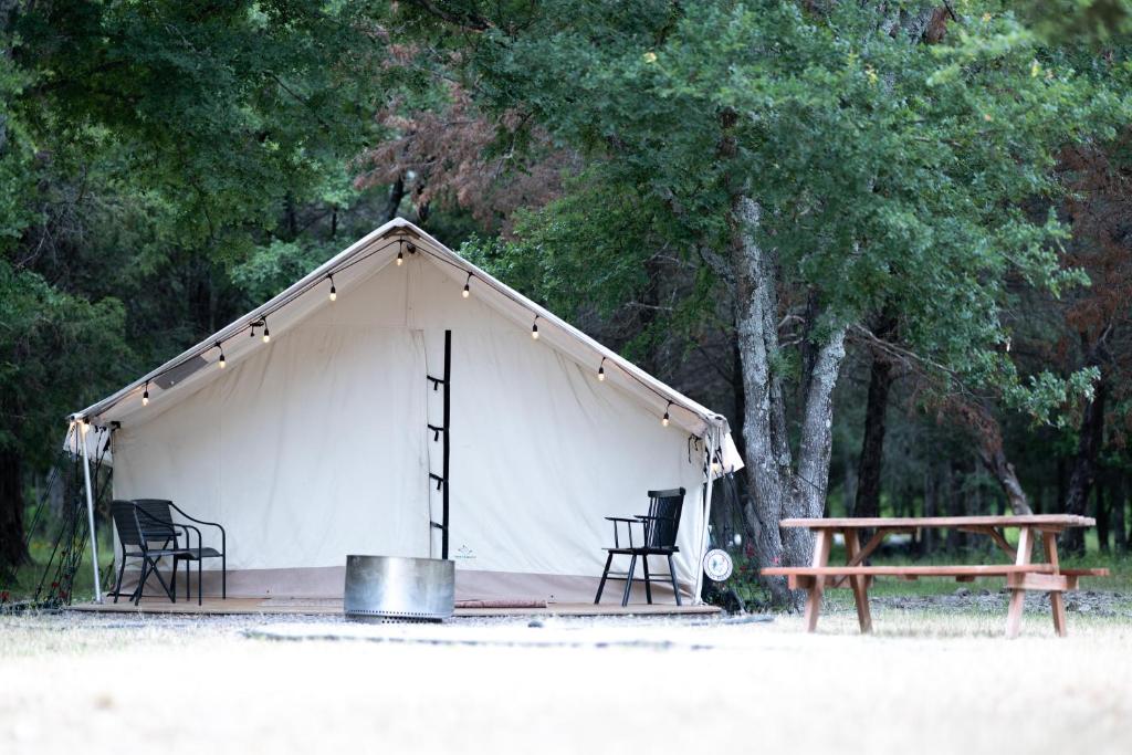 een tent met stoelen, een picknicktafel en een bank bij Farmstay Getaway 