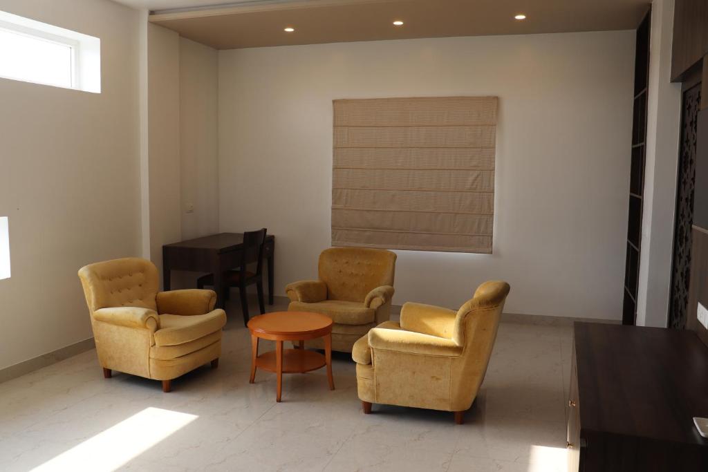 a waiting room with chairs and a table and a piano at Hotel Kana in Jodhpur