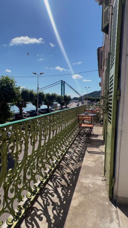 un balcon avec des bancs et un pont en arrière-plan dans l'établissement Appartement privé « Rive Droite », à Serrières