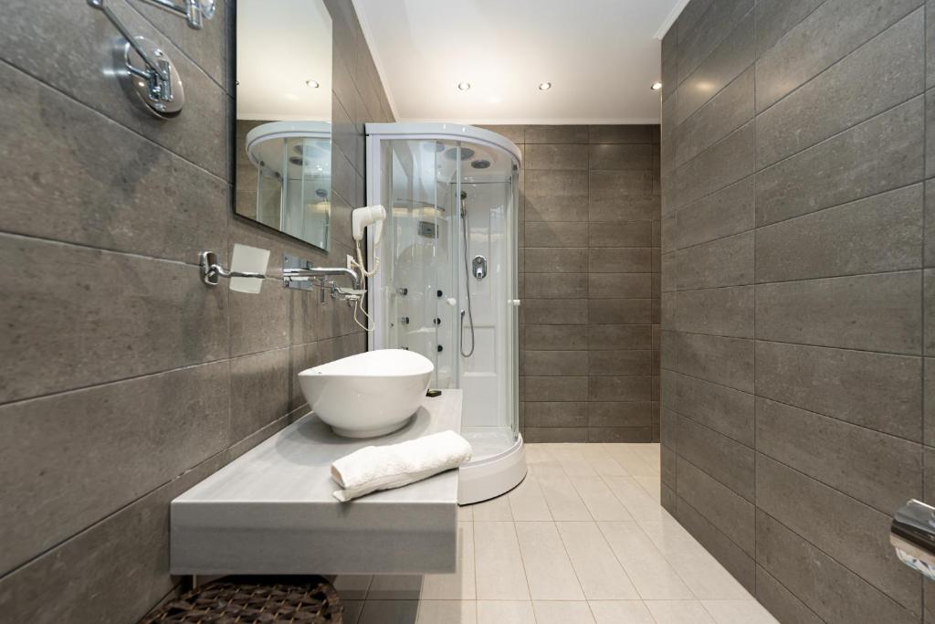 łazienka z umywalką i prysznicem w obiekcie Milonas House Apartments w mieście Paralia Dionisiou