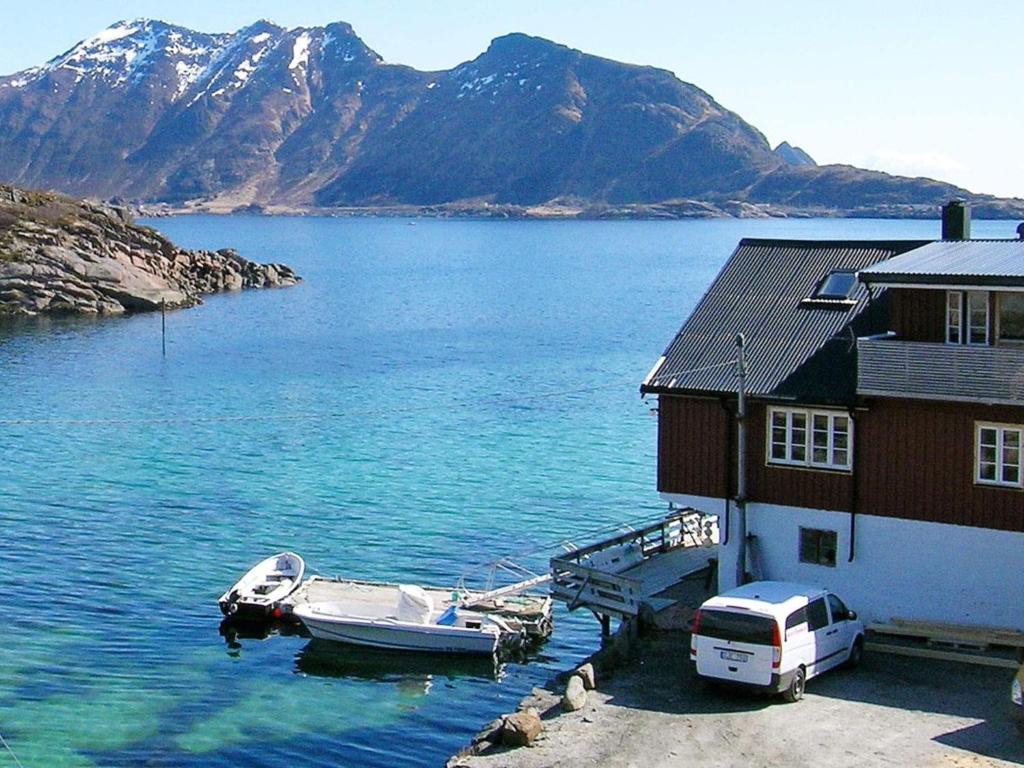 バルスタにあるTwo-Bedroom Holiday home in Ballstad 1の水上の家の隣に停泊している船