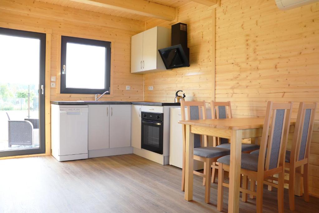 a kitchen with a table and a wooden wall at Nowy Domek Pod Czereśniami in Wisełka