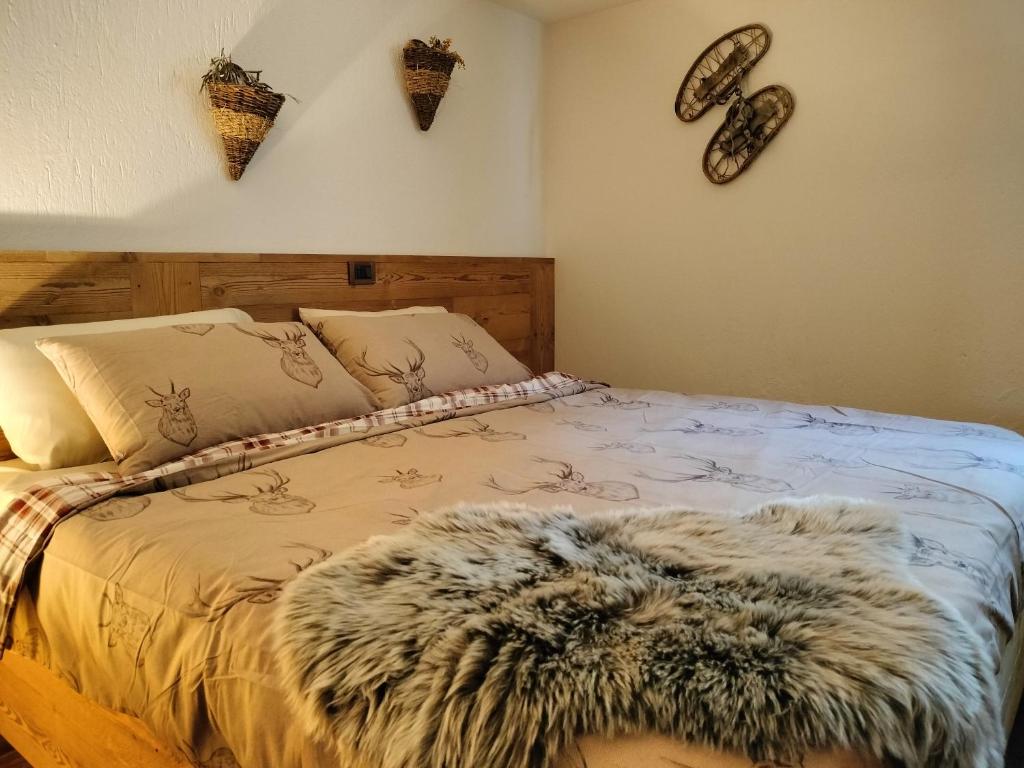 a bedroom with a bed with a fur rug on it at Le chalet du village in Chambave