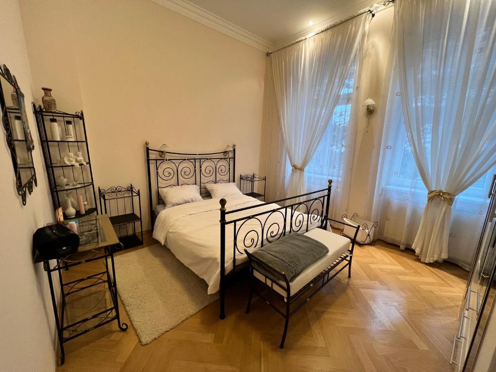 a bedroom with a bed and a chair and a window at Sadova luxury apartment in Karlovy Vary