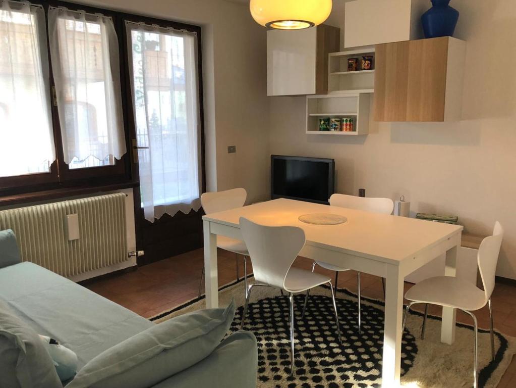 een woonkamer met een witte tafel en stoelen bij 051 Trilocale piano terra, Pinzolo in Pinzolo