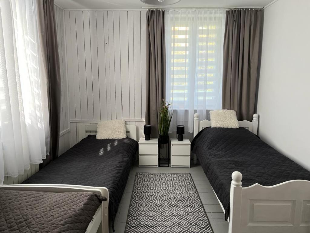 een slaapkamer met 2 bedden voor een raam bij Domek Mazury Pisz in Pisz