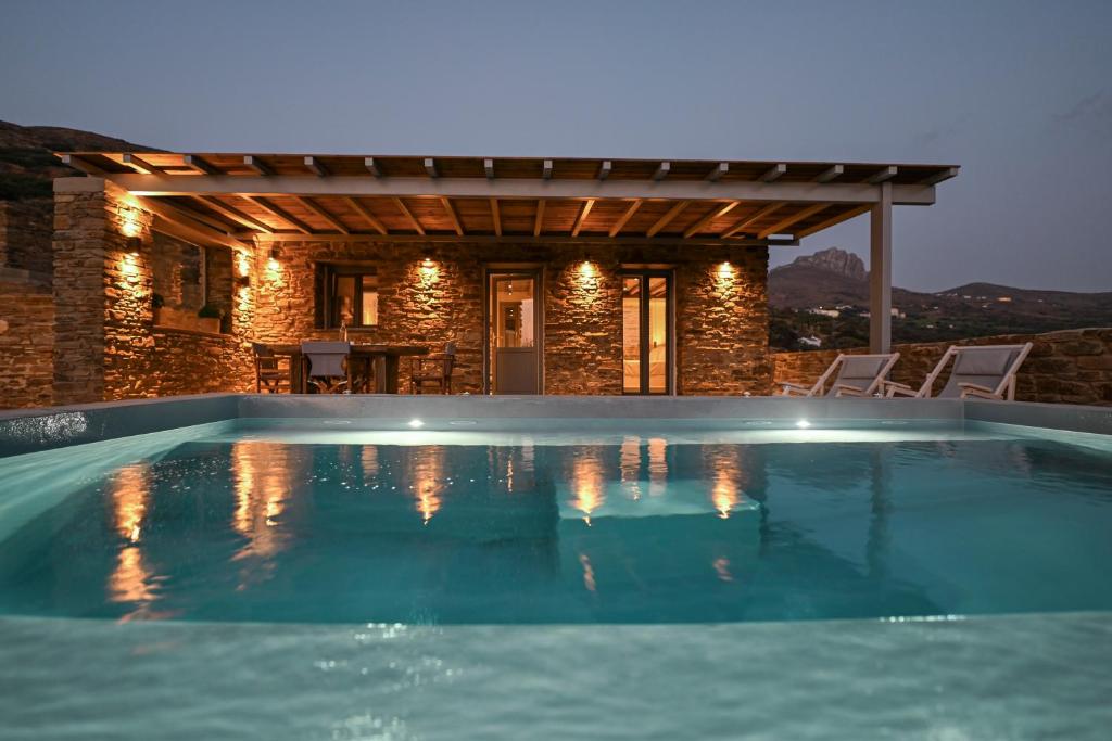 a swimming pool in front of a house at Celini villa Tinos in Krokos