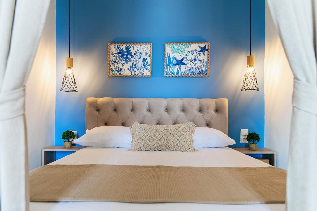 um quarto com paredes azuis e uma cama grande em Aqua Heaven em Iraklitsa