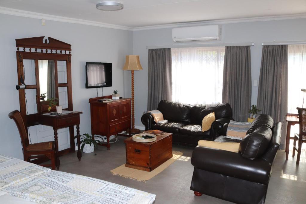 a living room with a couch and a table at Giraffe's Rest, Self Catering Studio Apartment in White River