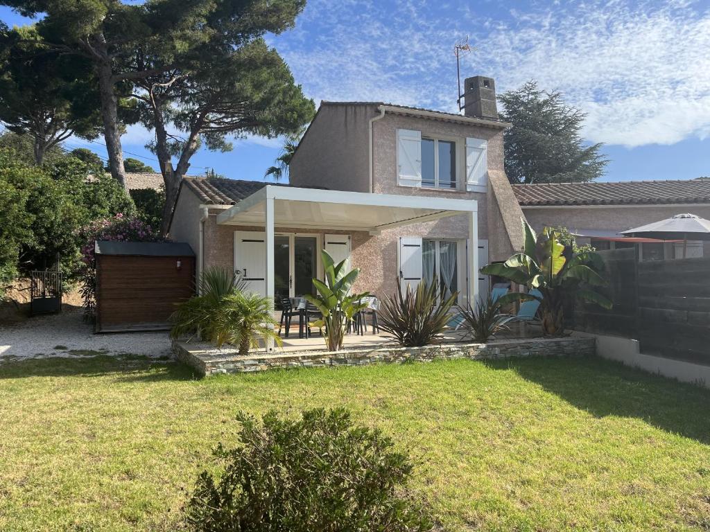 uma casa com um relvado em frente em Le Verger, villa lumineuse et agréable avec son espace extérieur clos au cœur de notre vignoble em Hyères