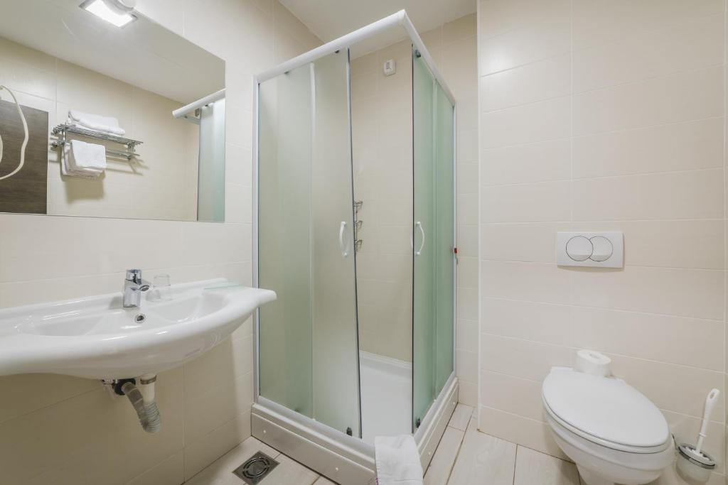 a bathroom with a shower and a sink and a toilet at Hotel & Apartments HEC Residence in Sveti Stefan
