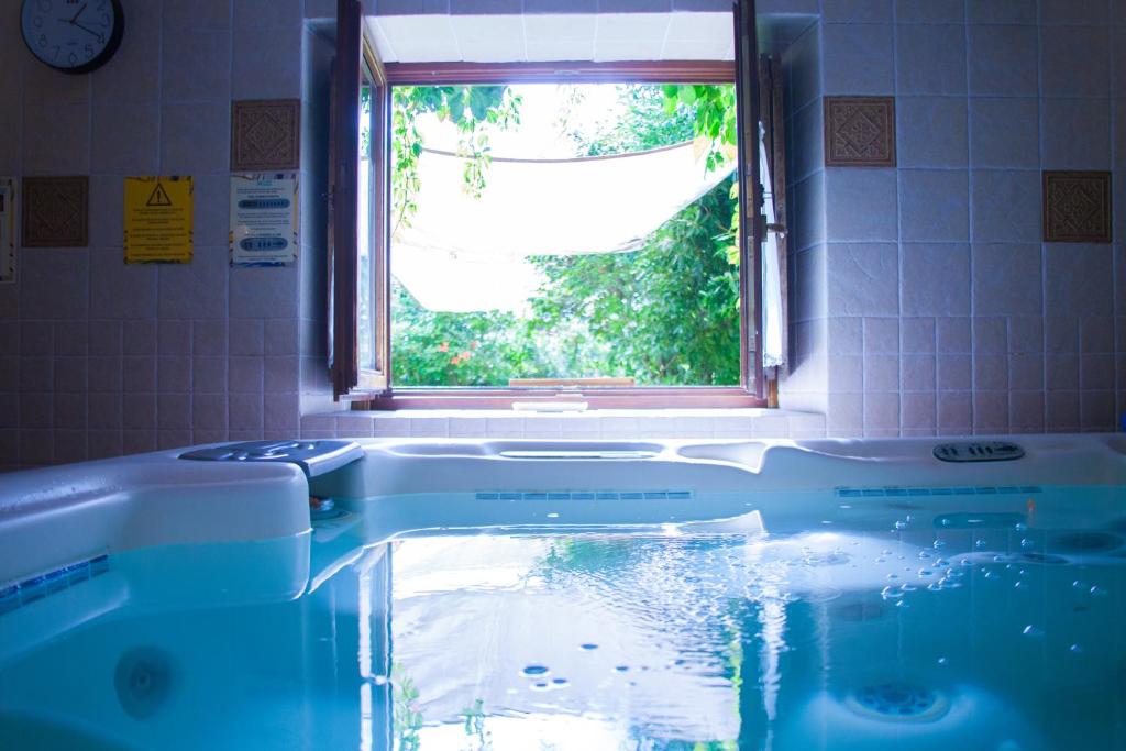 a bath tub with a window in a bathroom at La Erilla in Braojos de la Sierra