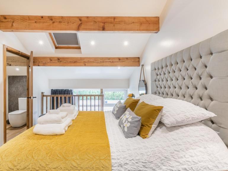 a bedroom with a large bed with a large headboard at south view farm cottage in Bradford