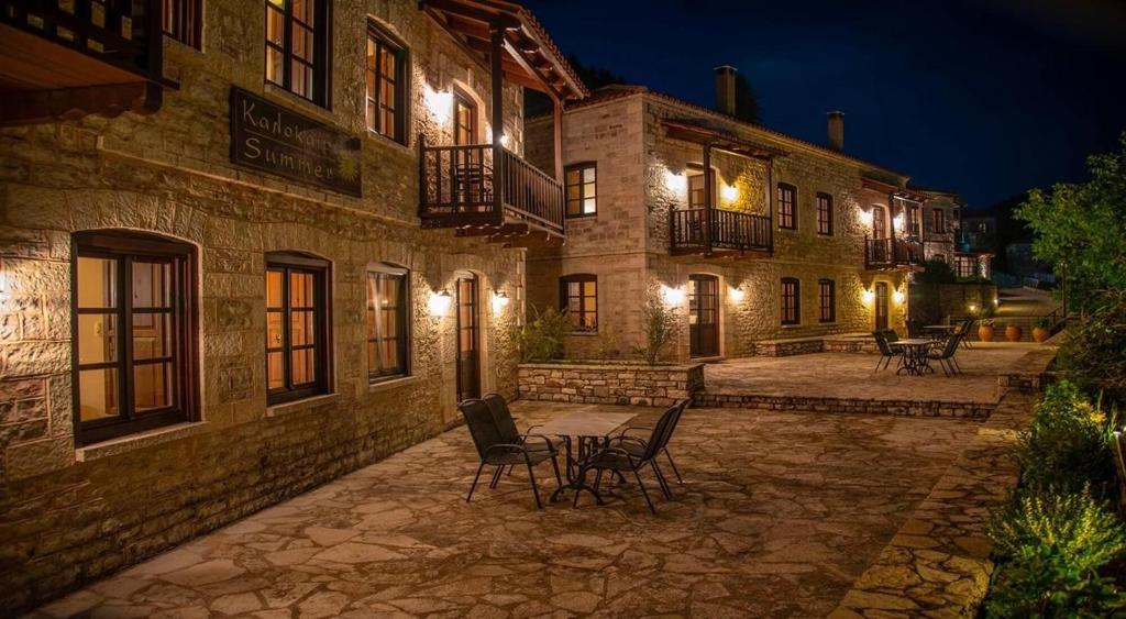 ein Gebäude mit Stühlen und Tischen in einem Innenhof in der Nacht in der Unterkunft Epoches Luxury Suites in Karpenisi