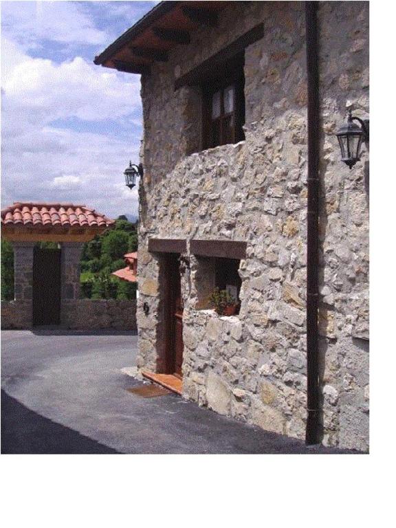 a stone building with a door and a porch at Casa El Carrelu in Po