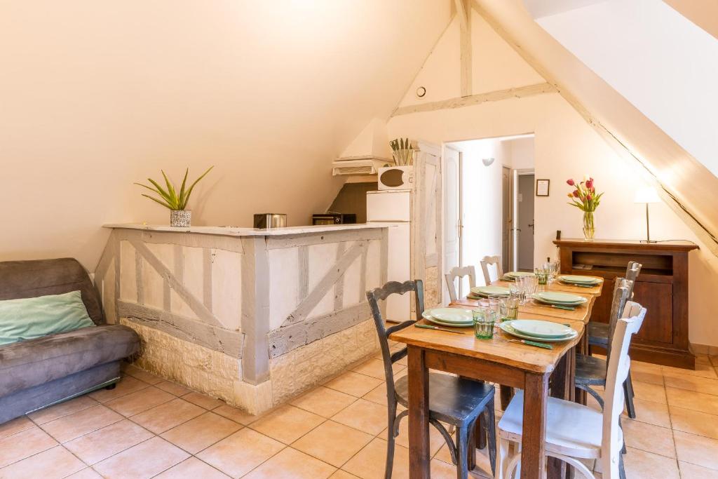 - une salle à manger avec une table et un canapé dans l'établissement Gites - Domaine de Geffosse, à Pont-l'Évêque