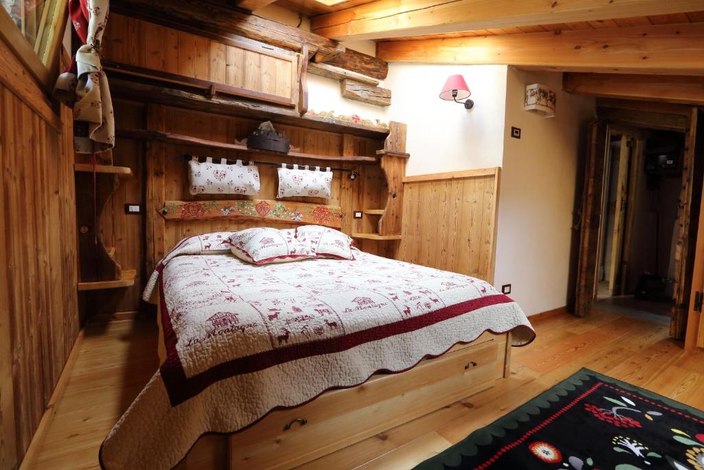 een slaapkamer met een bed in een blokhut bij La Cincia in Morgex