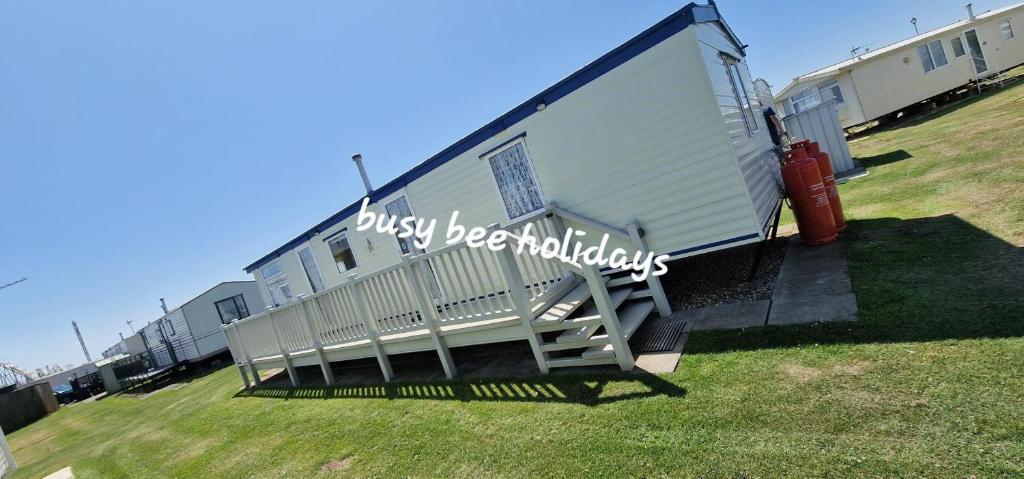 a white trailer with a staircase in a yard at The Hive on The Chase Ingoldmells in Skegness