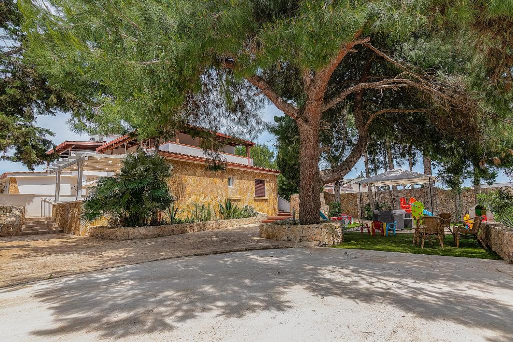 une maison avec un grand arbre dans l'allée dans l'établissement Residence Dolce Vita, à Torre Lapillo