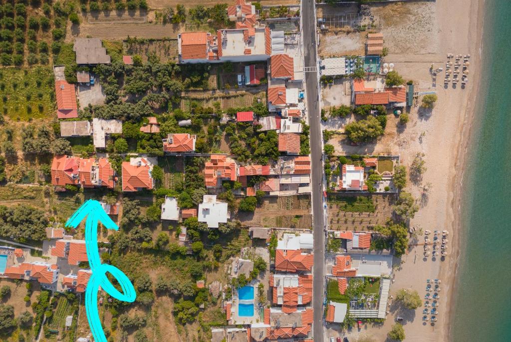 una vista aérea de una ciudad con casas y una flecha azul en Lemon Tree Apartments Samos, en Votsalákia