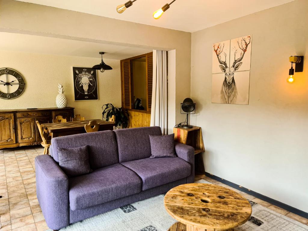 a living room with a purple couch and a table at Appt les Granges - Vue montagne et village, Centre la Clusaz - AravisTour in La Clusaz