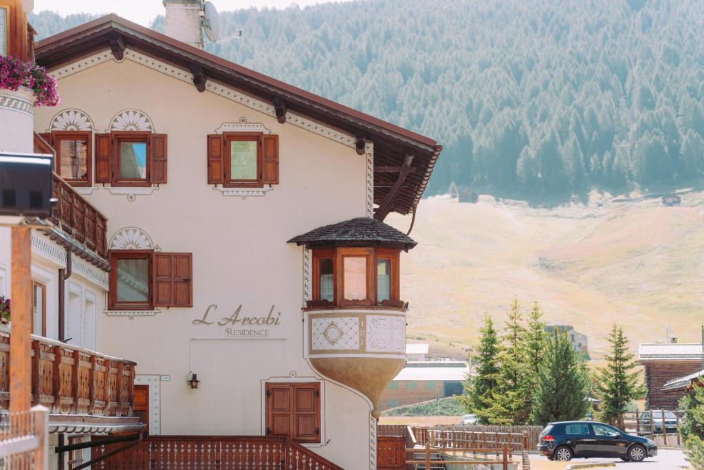 una casa con balcone affacciato su una montagna di Residence L'Arcobi a Livigno